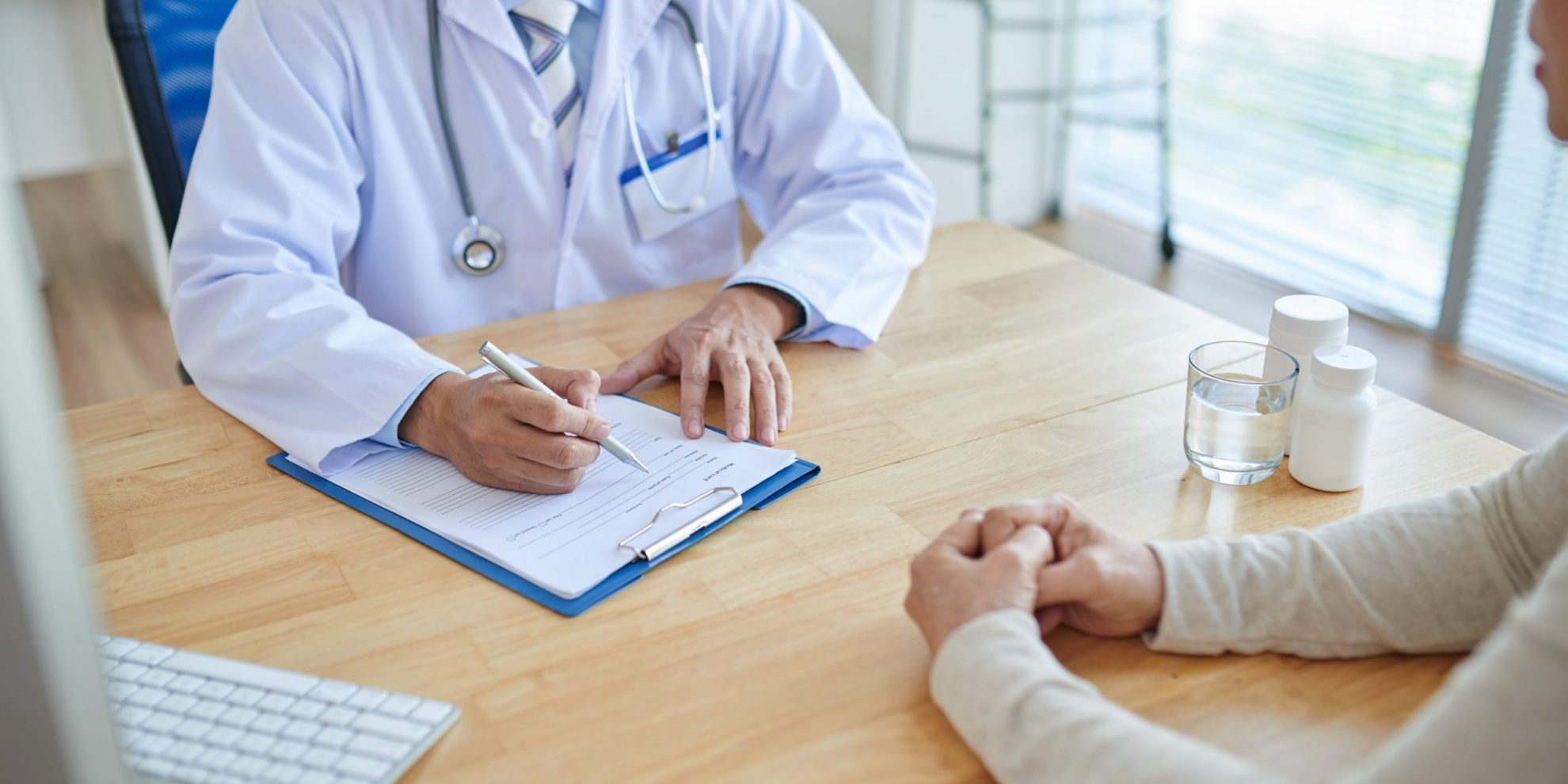 Photo of doctor with patient illustrates blog:; "The Importance of Accurate and Compliant Med-Legal Reports in California"