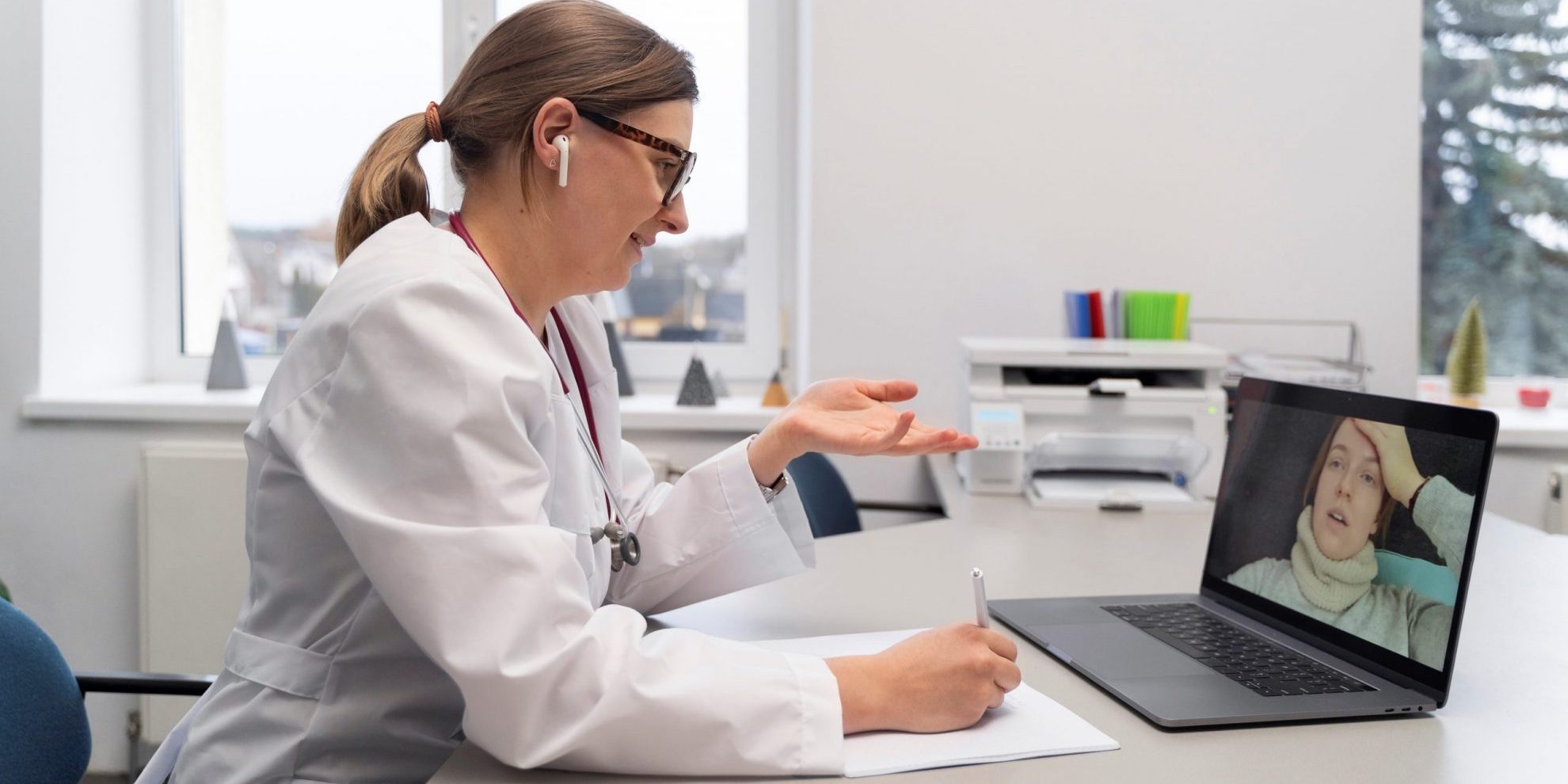 Photo of woman doctor in front of laptop illustrates blog: "Emergency Regulations for Medical-Legal Evaluations in California: What You Need to Know"