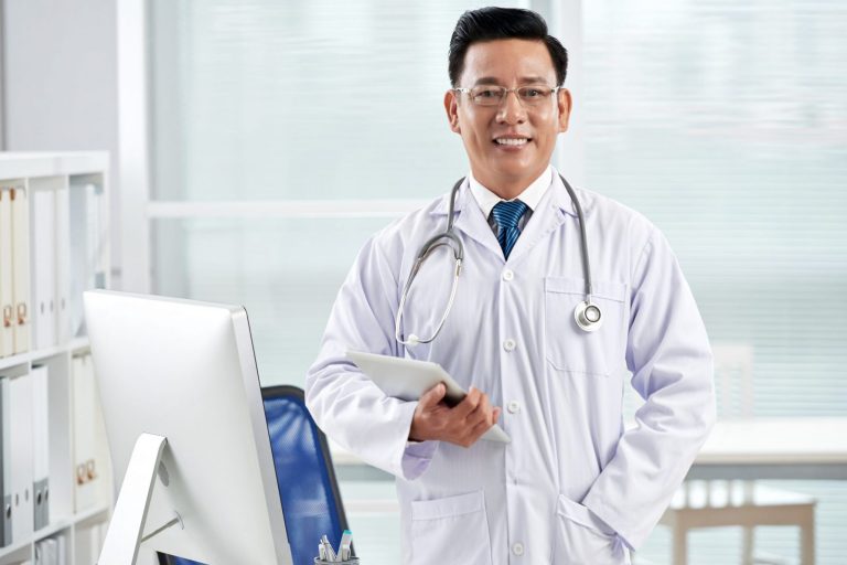 Photo of doctor in his office illustrates blog: "7 Essential Terms To Understand Medical Legal Billing in California"