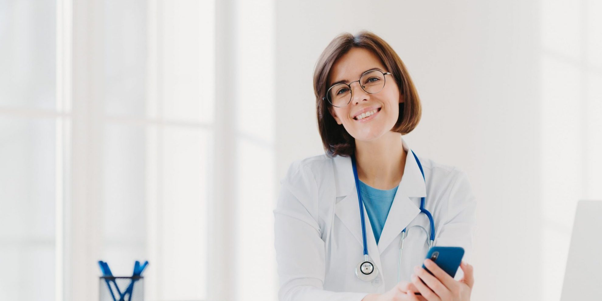Photo of smiling doctor in her office illustrates blog: "Can an IBR Determination Be Appealed?"