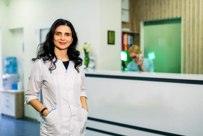 Photo of woman wearing white coat in doctor's office illustrates blog: "Medical Legal Billing in California: What Is the Medical Legal Fee Schedule?"
