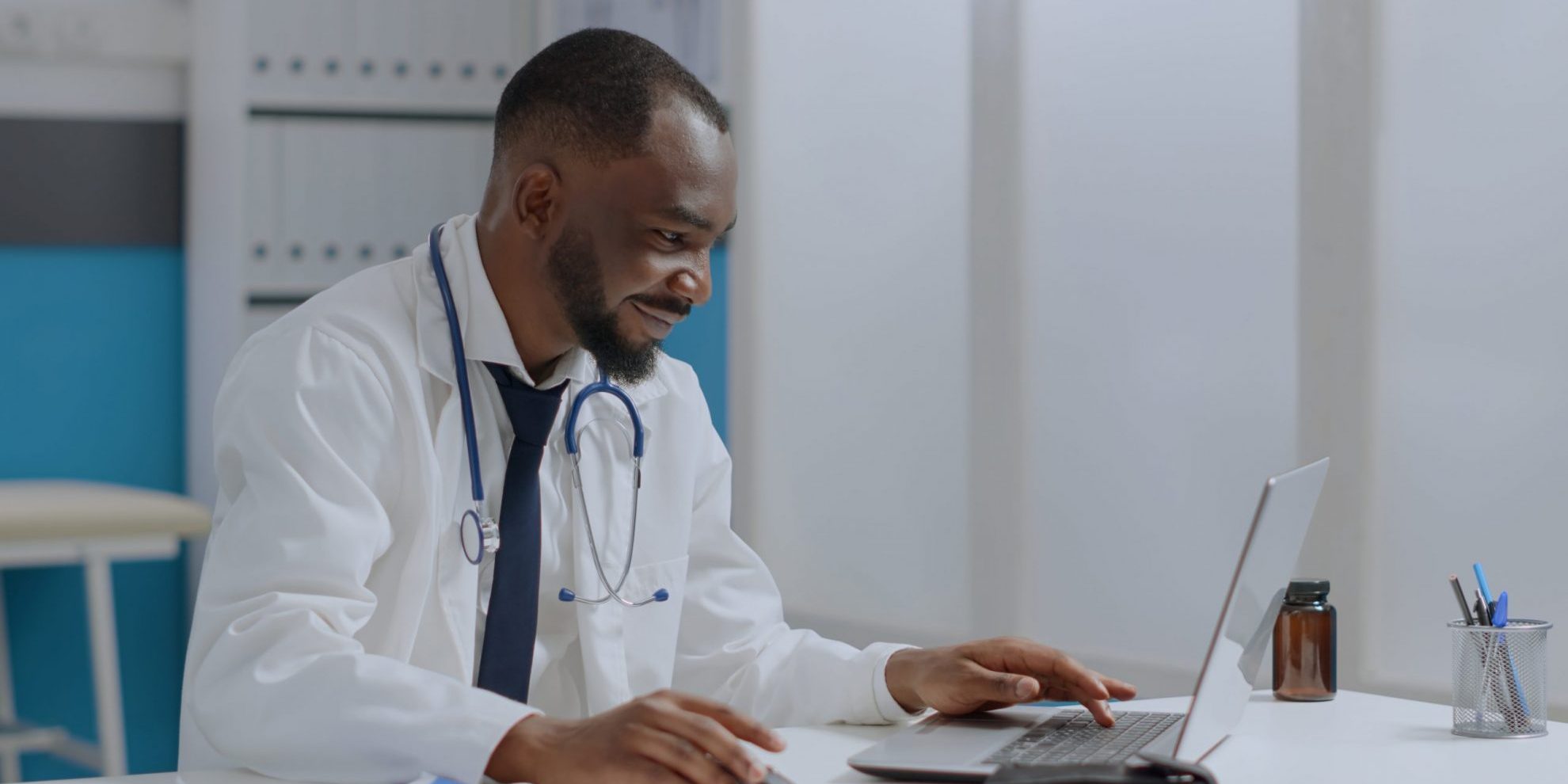 Photo of doctor looking at laptop illustrates blog: "What Is a Medical Legal Expense?"
