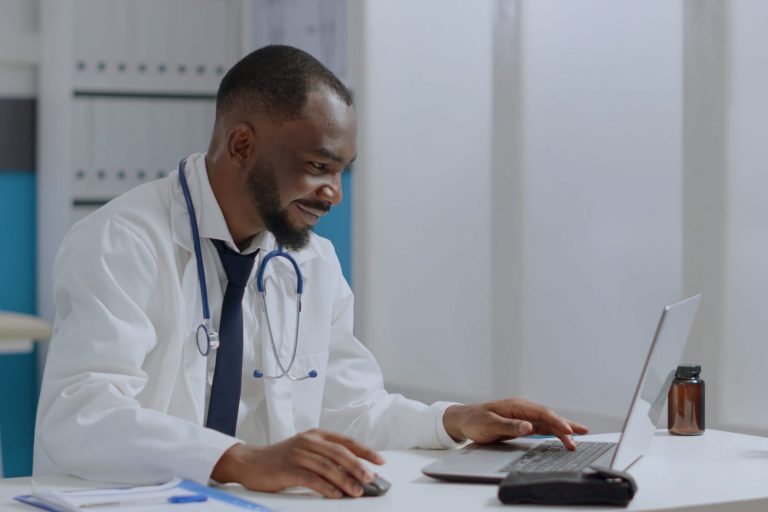 Photo of doctor looking at laptop illustrates blog: "What Is a Medical Legal Expense?"