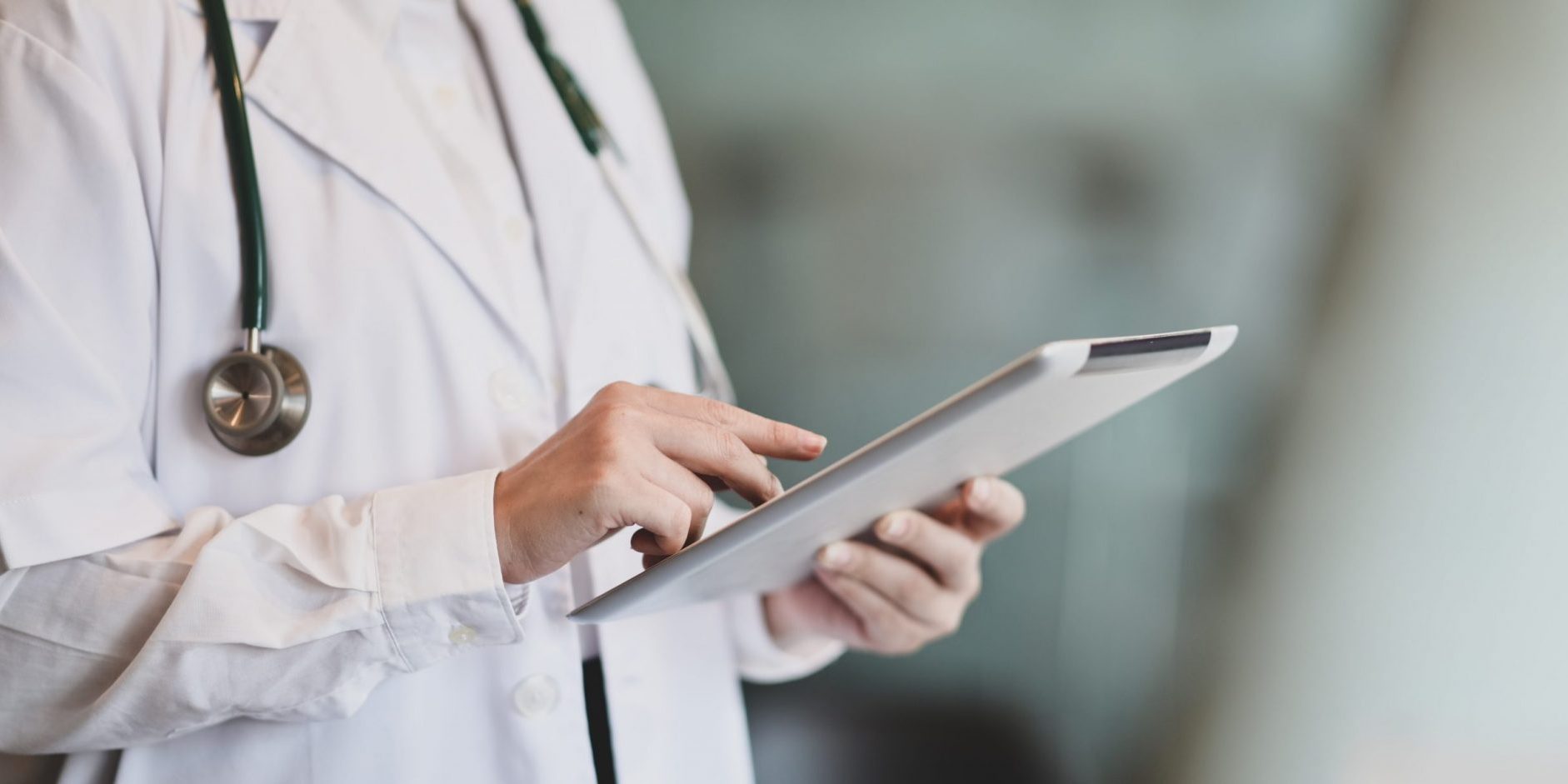 Photo of doctor holding tablet illustrates blog: "California Workers’ Comp Glossary"