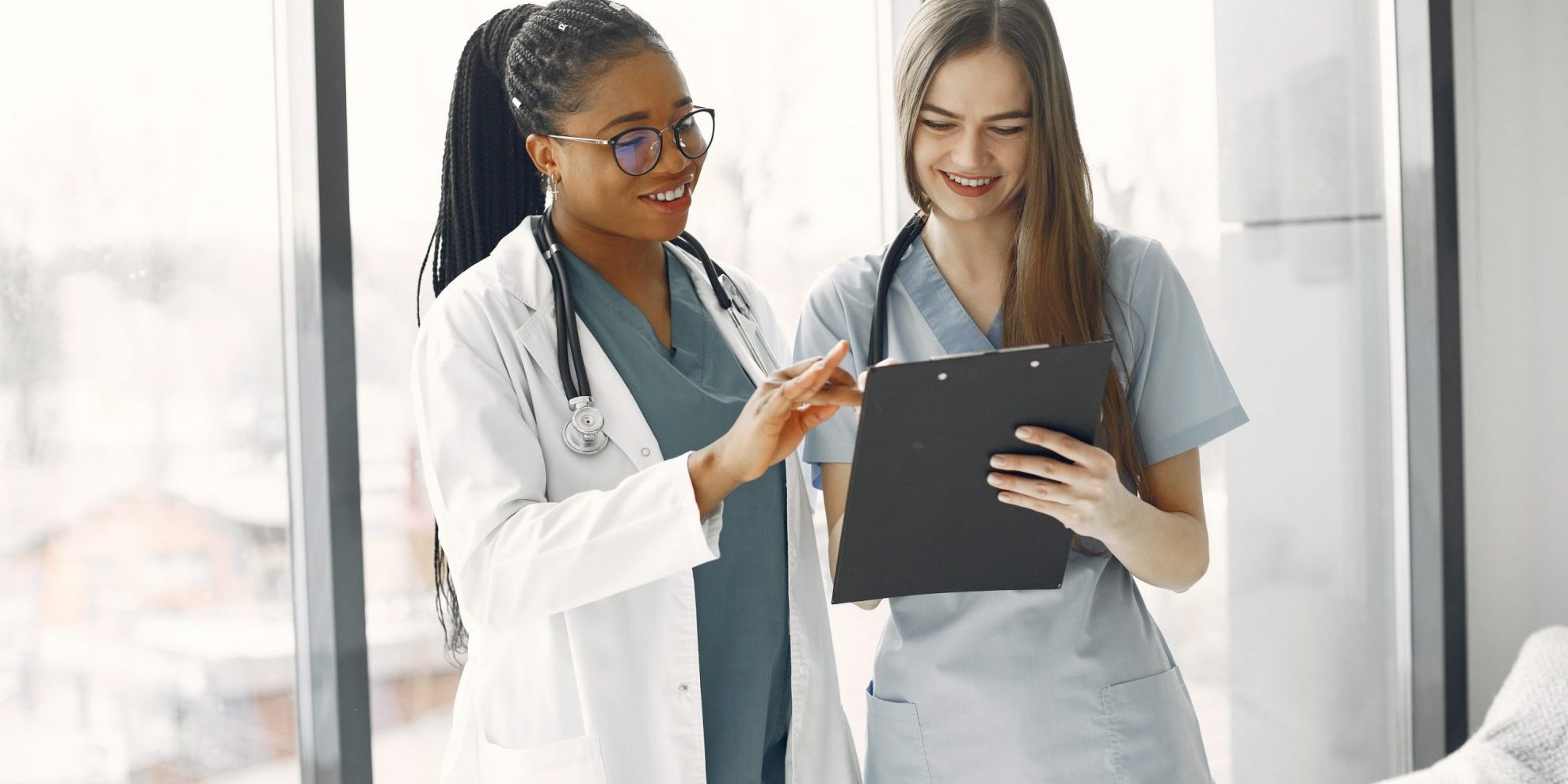 Photot of two smiling doctors illustrates blog; "California QME Exam Questions: What You Need To Know"