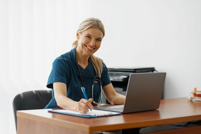 Photo of smiling woman in scrubs illustrates blog: "How To Request an Independent Bill Review (IBR)?"