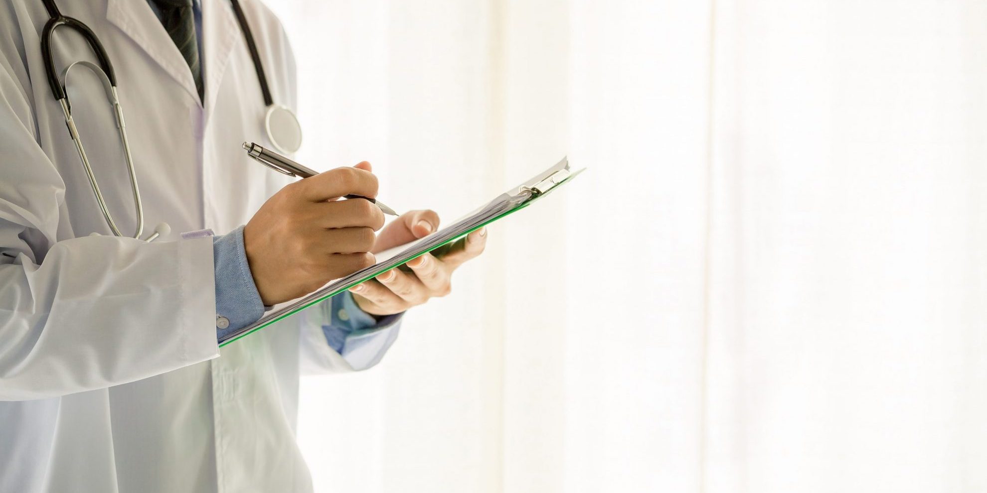 Medical physician doctor man over white background. Closeup of doctor writing on clipboard illustrates blog "California’s DWC Is Accepting Applications for April 2023 QME Examination"