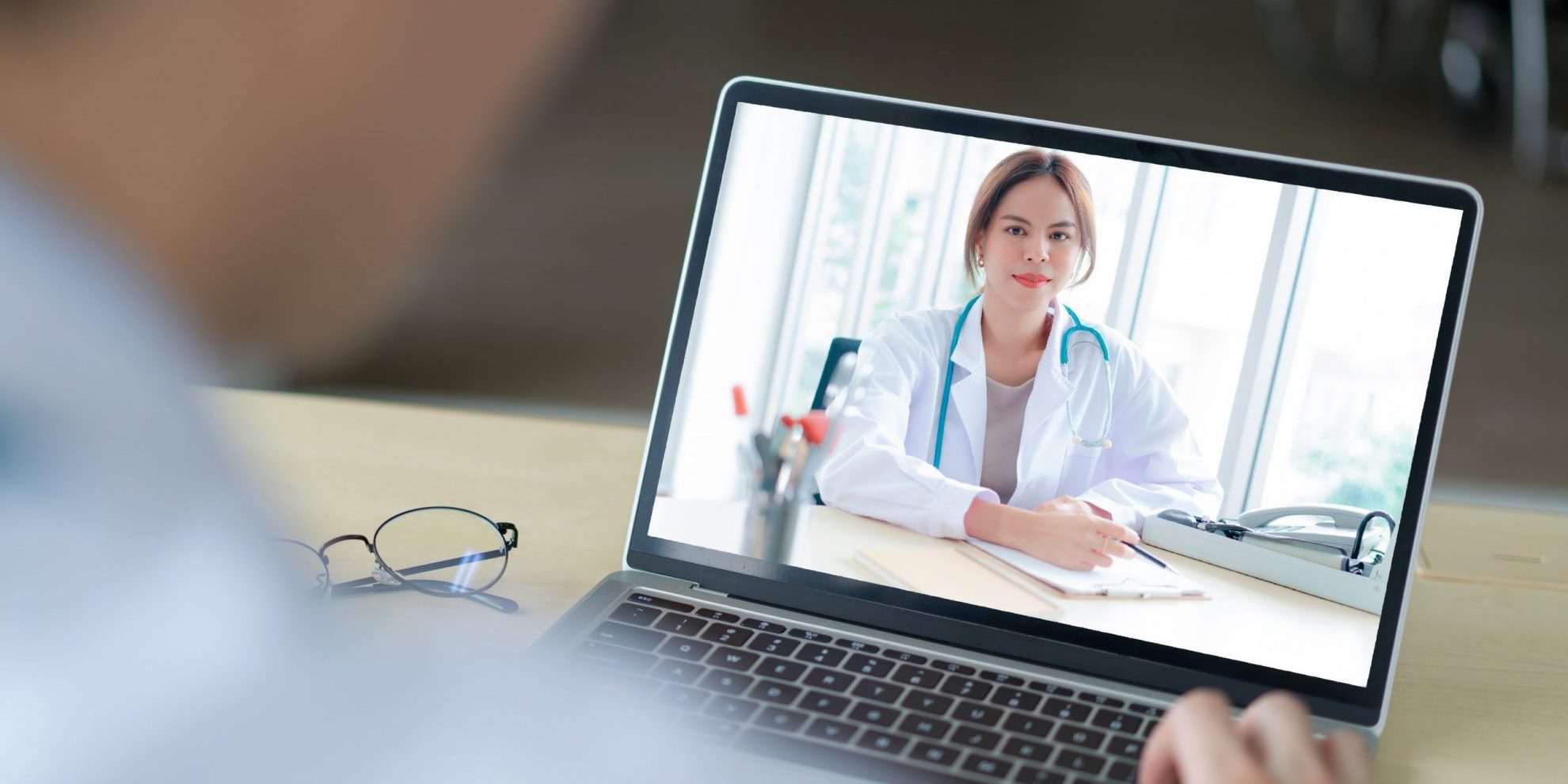 Image of woman doctor in laptop screen illustrates blog "OAL Approves DWC’s Medical-Legal Evaluation Regulations "