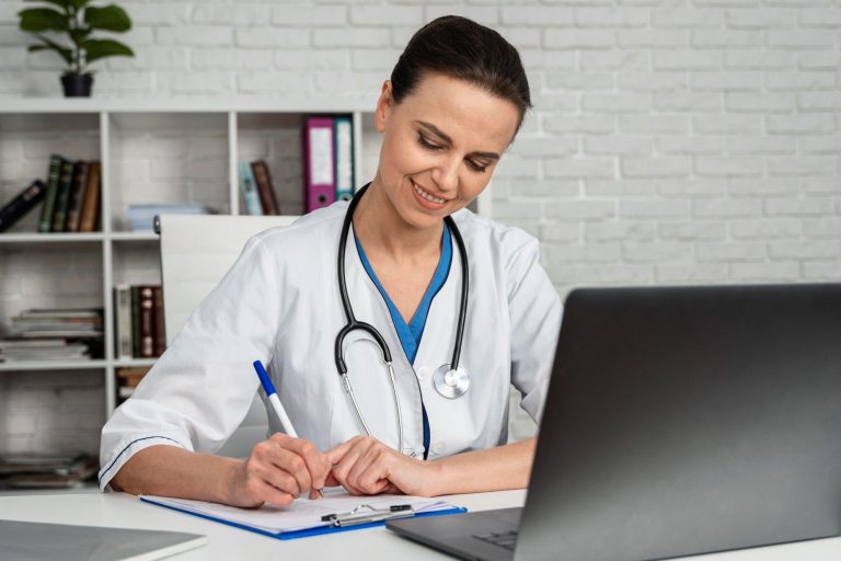 Female doctor writing in front of laptop illustrates blog "Can I Take the QME Examination Outside of California?"