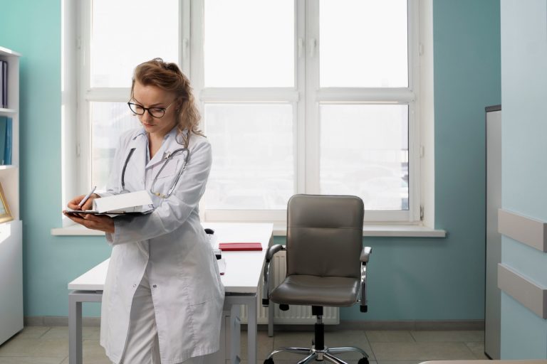 Female physician writing in an office illustrates blog "Medical Legal Evaluations: How Much Time Do I Have To Complete the QME Report?"