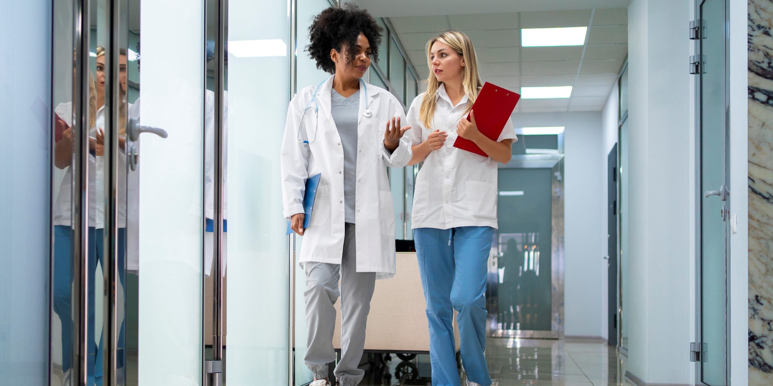 revenue-cycle-management Two female doctors walking side by side illustrate blog "What Is Revenue Cycle Management?"