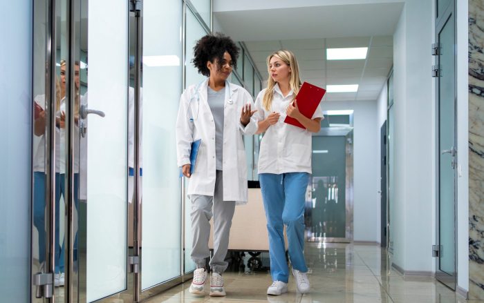 Two female doctors walking side by side illustrate blog "What Is Revenue Cycle Management?"