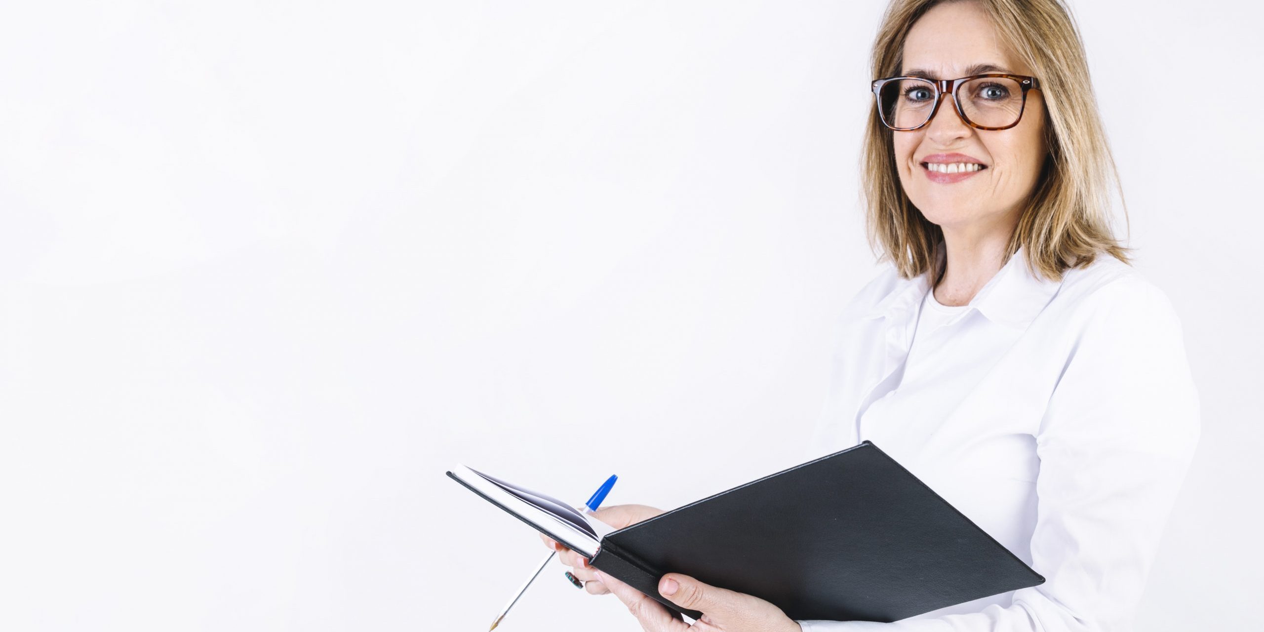 Woman in white lab coat holding open book illustrates blog "Essential Medical Billing Terms You Need To Know"
