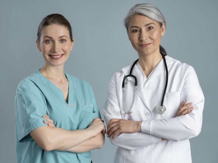 Two female doctors standing side by side illustrate blog "How Can QMEs Add Another Office Location?"