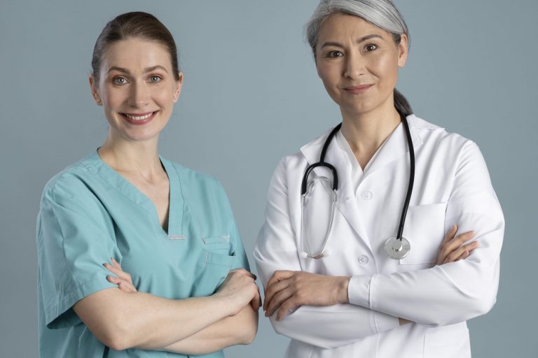 Two female doctors standing side by side illustrate blog "How Can QMEs Add Another Office Location?"