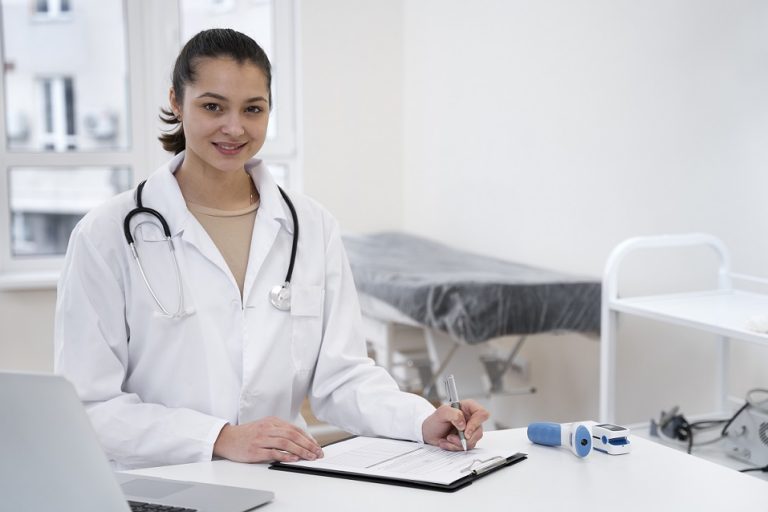 Female doctor sitting at desk illustrates blog "The Role of Healthcare Call Centers in Patient Care"
