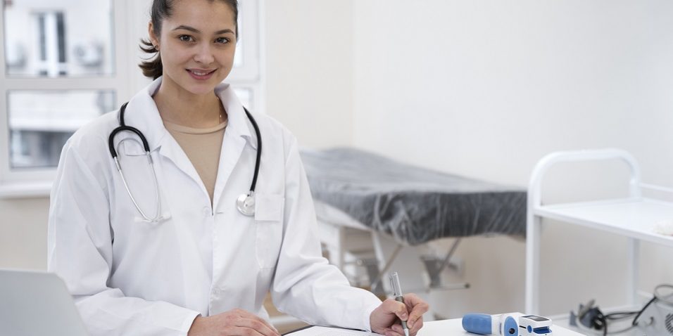 Female doctor sitting at desk illustrates blog "The Role of Healthcare Call Centers in Patient Care"