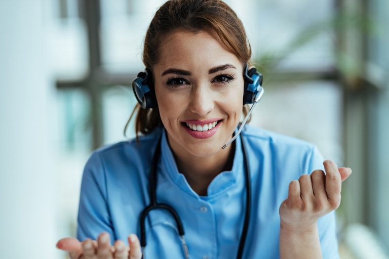 Woman in scrubs and call center headset illustrates blog "Enhancing Patient Experience Through Healthcare Call Center Innovations"