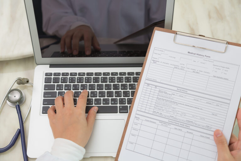 Doctor hands typing on laptop keyboard