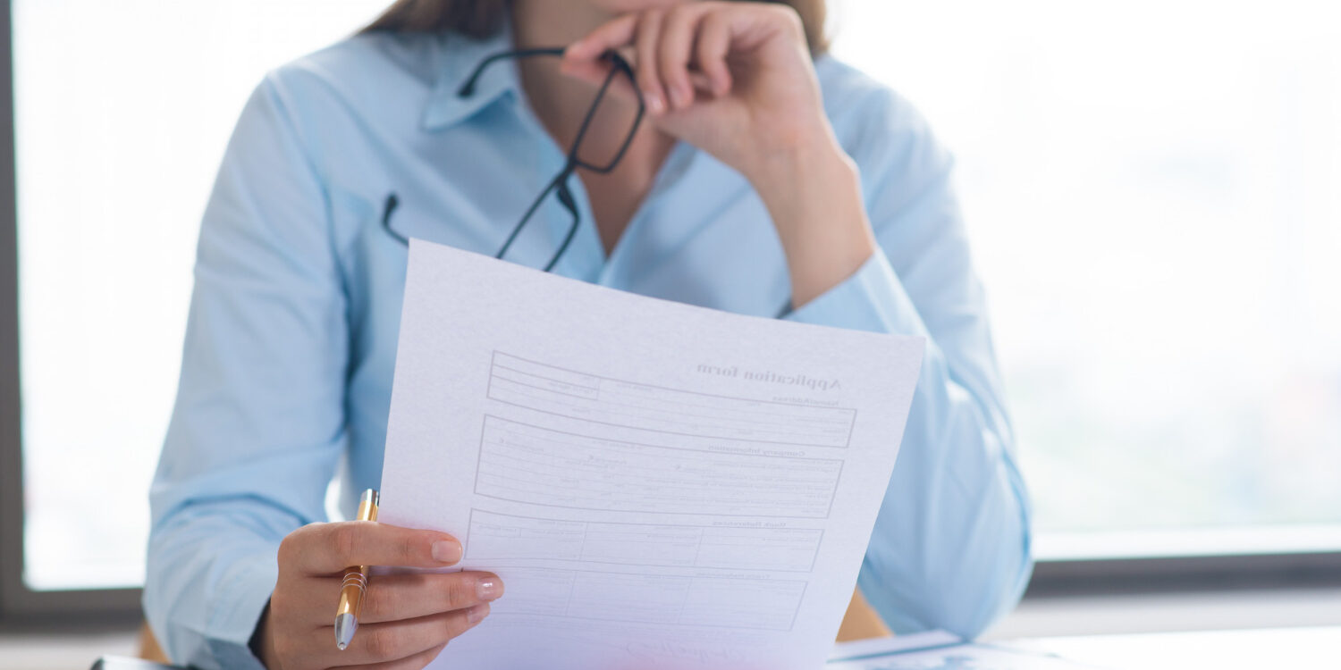 Healthcare administrator reviewing credentialing documents to prevent delays