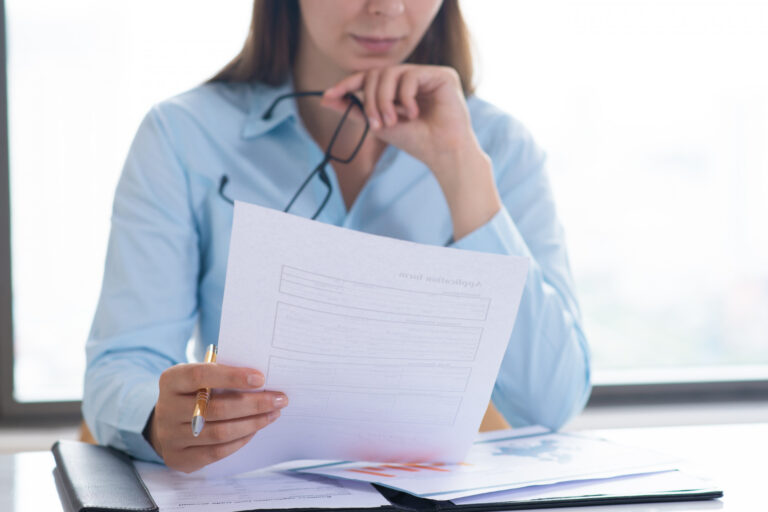 16067 Healthcare administrator reviewing credentialing documents to prevent delays