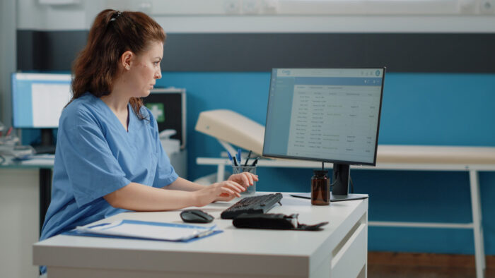 nurse-typing-computer-keyboard-consultation Digital mailroom management in a medical practice