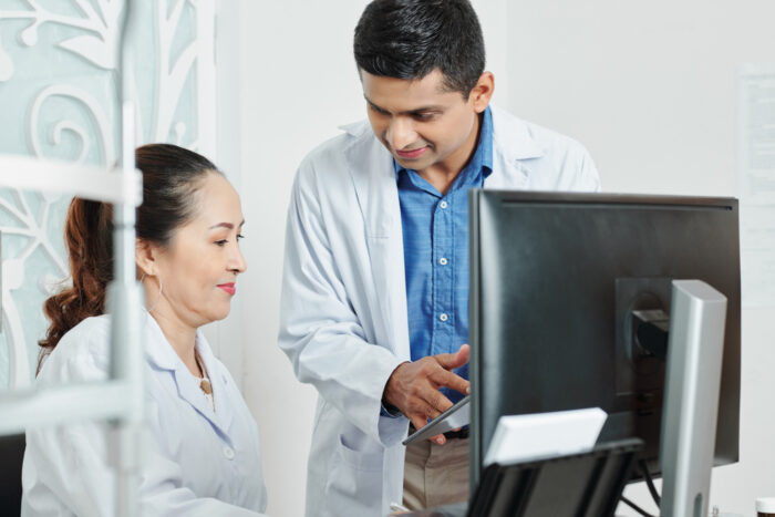 two-doctors-working-team-office ealthcare team reviewing automated scheduling system to reduce inefficiencies