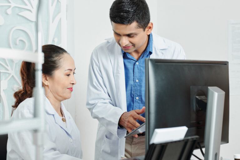 two-doctors-working-team-office ealthcare team reviewing automated scheduling system to reduce inefficiencies